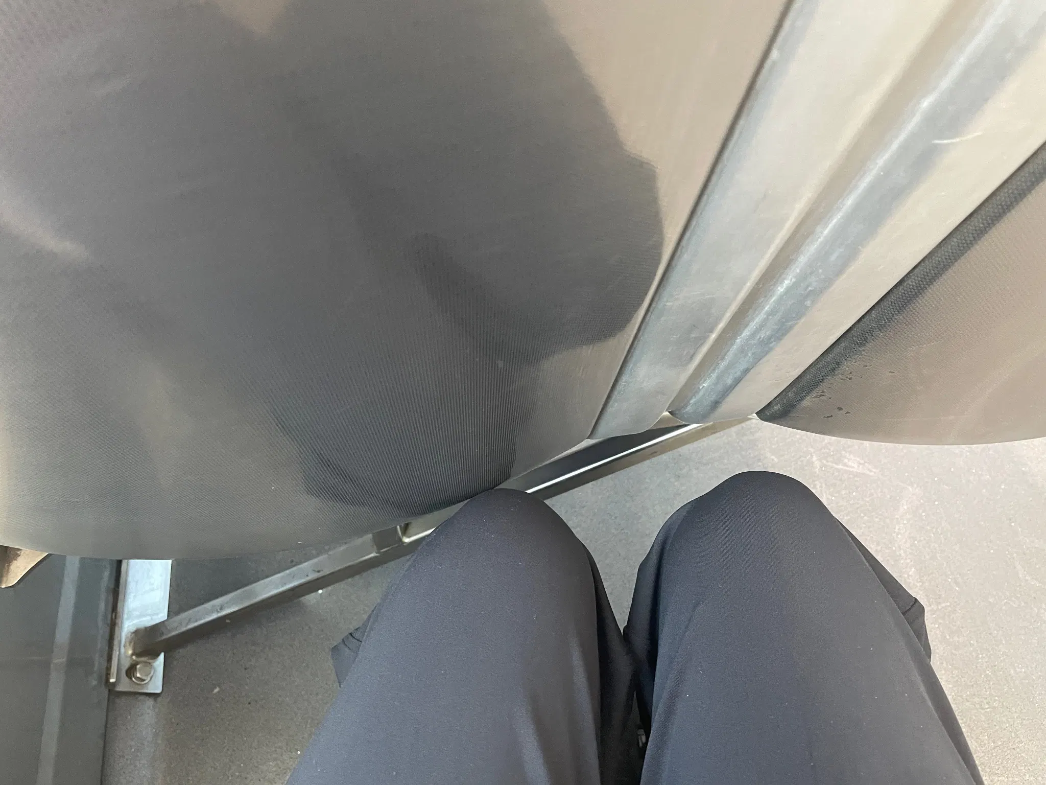 person wearing black pants sitting behind 2 streetcar seats