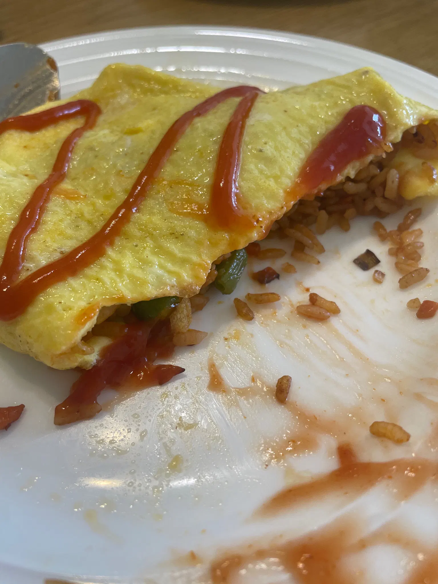ketchup fried rice inside an omelette with a ketchup drizzle